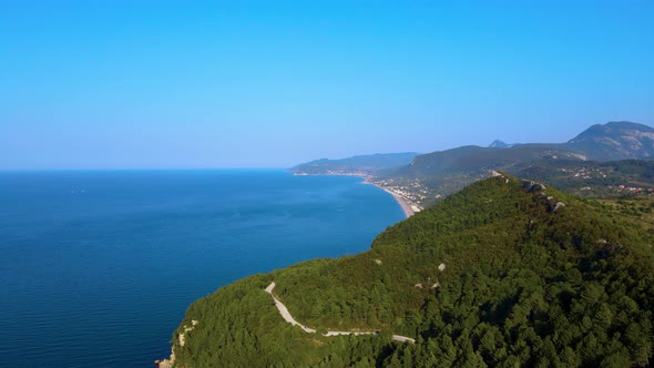 steep green mountains, deep forest and mountain road, beautiful valley and blue sea
