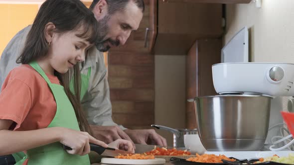 A man with a child prepare food.