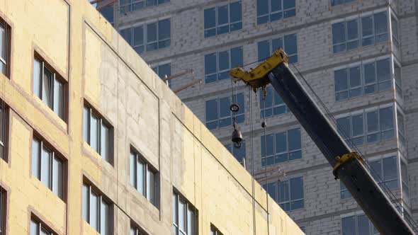 Moving of a Building Construction Crane Over the Skyscrapper