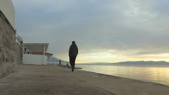 Man walking along seafront walkway