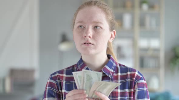 Serious Young Woman Counting Money