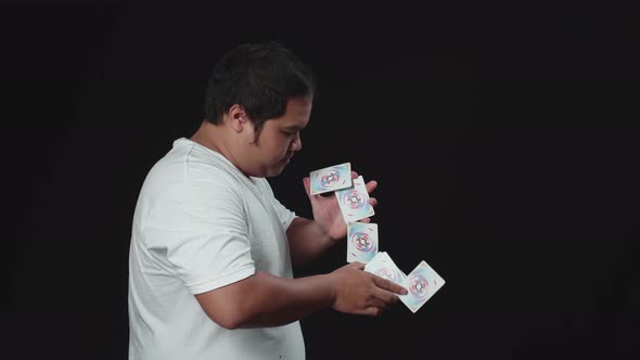 Asian Man Showing His Trick With Usual Cards