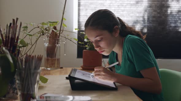 Teenage girl drawing using a tablet computer and an electronic pen