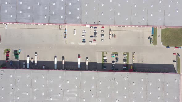 Aerial Shot of Truck with Attached Semi Trailer Leaving Industrial Warehouse/ Storage Building/ Load