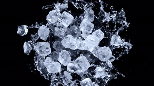 Super Slow Motion Shot of Rotating Exploded Ice Cubes and Splashing Water on Black at 1000Fps alt