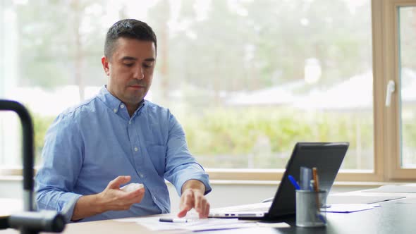 Man Using Hand Sanitizer at Home Office