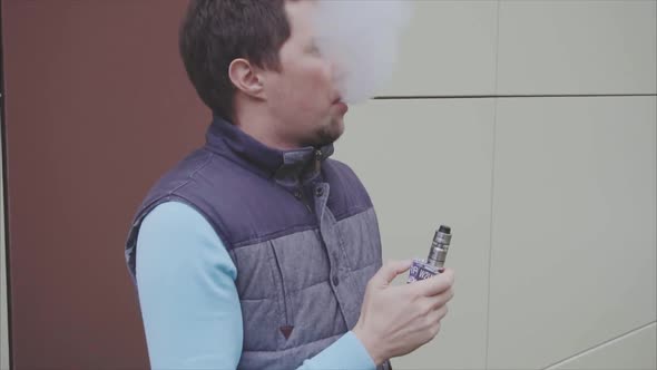 Young Vaper Man Exhaling Big Clouds of Smoke with Ecigarette Vape Slow Motion