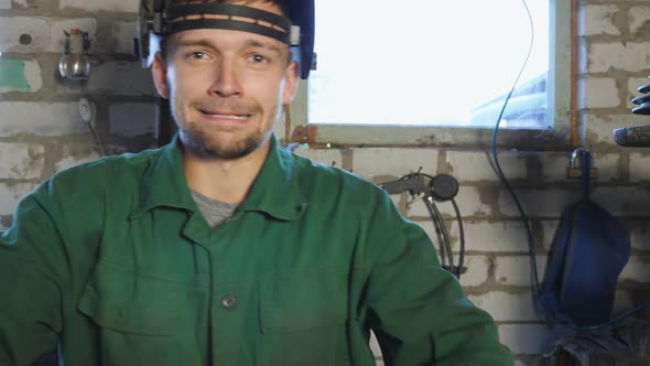 Young Repairman Taking Off Protective Eyewear and Showing Grimaces Into Camera