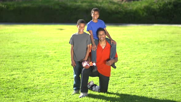 Group portrait of a father and his sons with a football.