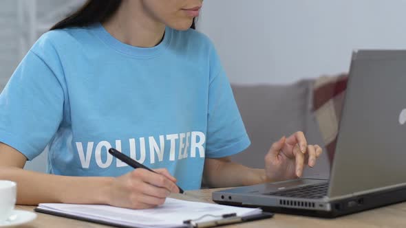 Young Lady Volunteer Working on Laptop and Making to Do List, Planning Budget