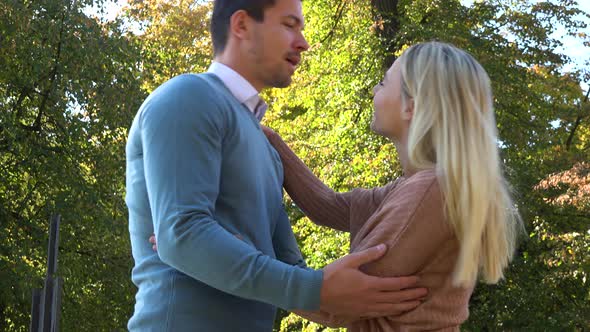 A Man and a Woman Hug and Talk in a Park on a Sunny Day - Closeup From Below