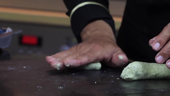 An Experienced Chef in a Professional Kitchen Prepares the Dough  with Flour