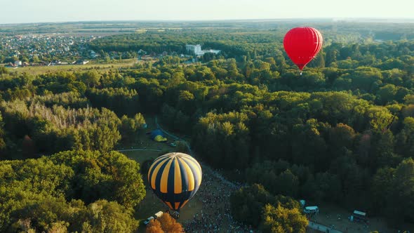 Hot Air Balloons Takes Off Among the Trees in the Park at the Sunset. Aerial Footage