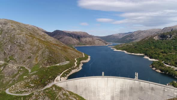 Modern Dam Reservoir on Blue Lake Waters Generate Alternative Energy in Highland Wild Area