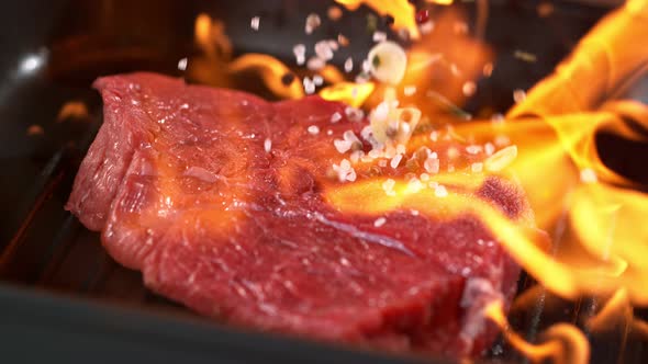 Super Slowmotion Footage of Throwing Fresh Beef Meat and Seasoning on Ignited Pan 1000Fps