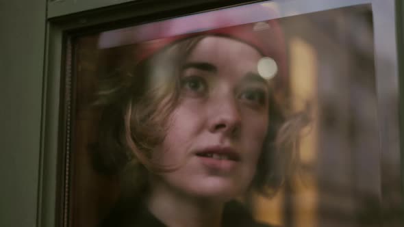 Young Romantic Girl Looking Through The Window Glass.