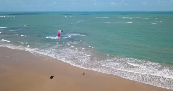 Aerial drone view of a woman walking after kiteboarding on a kite board