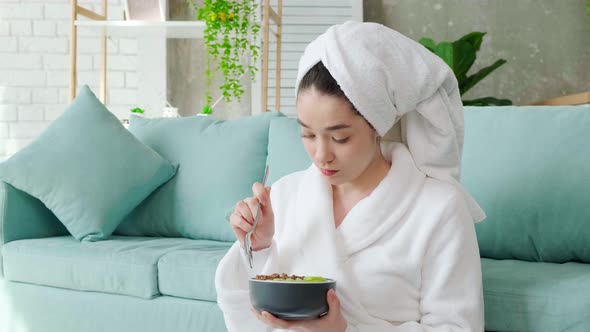 Lady Sitting Near Sofa After Shower and Eating Granola with Yogurt and Fruit