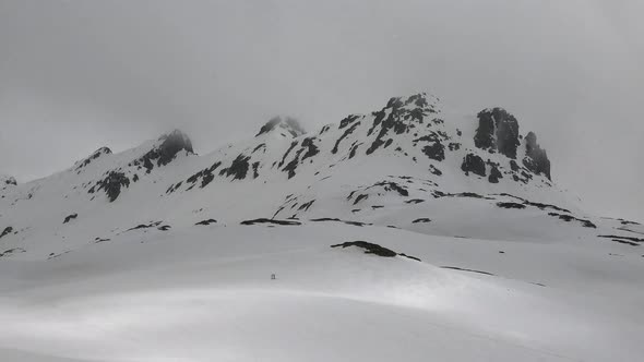 High Altitude Rocky Snowy Mountain Ridge in Overcast Winter Day