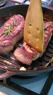 Man Prepares a Beef Steak on a Grill Pan in the Kitchen of the House