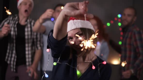 Pretty Girl with Colorful Lights on Neck and Santa Hat Posing for Camera Smiling Waving Her Bengal