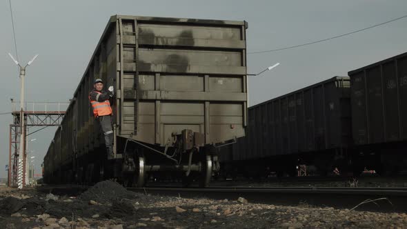 Worker Rides on Train Car