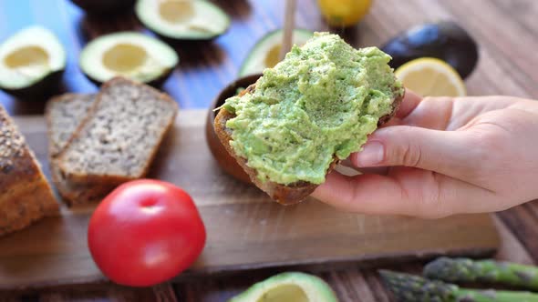 Closeup Of Hand Peppering Avocado Toast