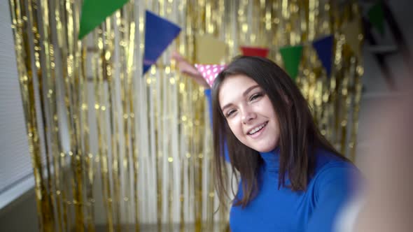 A Young Cheerful Girl Celebrates Her Birthday at Home with Decorations Alone Communicates on a