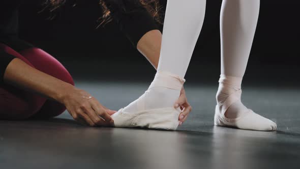 Unrecognizable Woman Coach Teacher Teaches Helping Girl Ballerina to Stand on Pointe Shoes Do