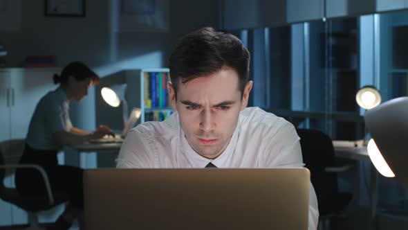 Close Up of Serious Employee Read Information on Laptop Working Late