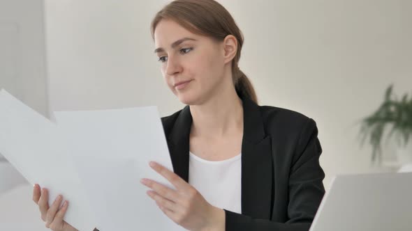 Young Businesswoman Reading Contract at Work