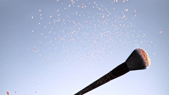 Super Slow Motion Shot of Flying and Rotating Makeup Brush and Brown Powder at 1000Fps