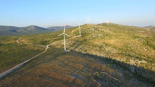 Aerial view of windmills with rotating blades on a sunny day