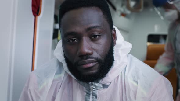 Black Paramedic in Protective Clothes Looking at Camera