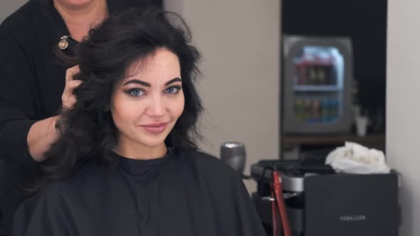 a Young Attractive Girl Is in a Hair Styling Salon, Pleased with the Result, Smiling at the Camera