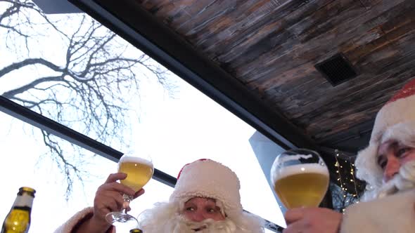 A Group of Santa Clauses Wish Merry Christmas and Drink a Glass of Light Beer