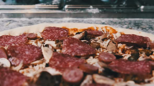 Appetizing Raw Pizza Dough with Chopped Ingredients Lies on the Kitchen Surface.