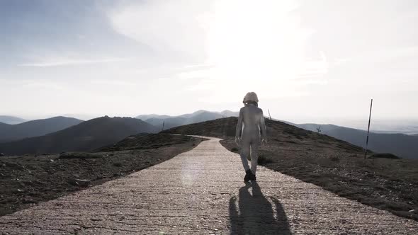Spaceman walking on path in countryside