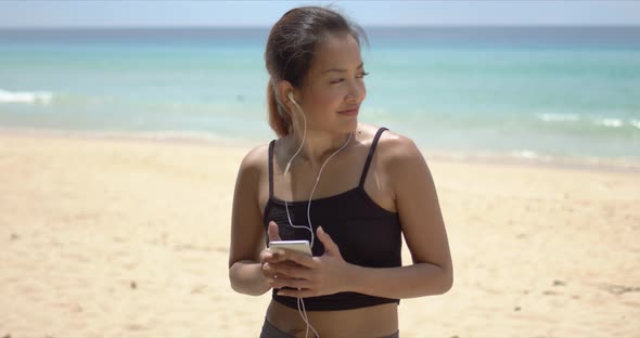 Happy Sportswoman Listening To Music During Training