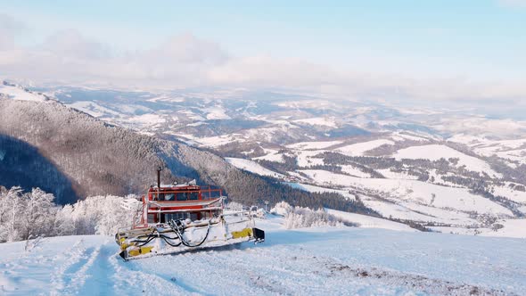 Red Snowplow Removing Fresh Snow Down Hill