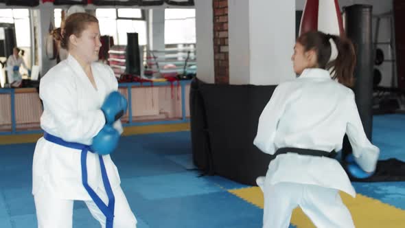 Two Female Kickboxers Exercising in Gym