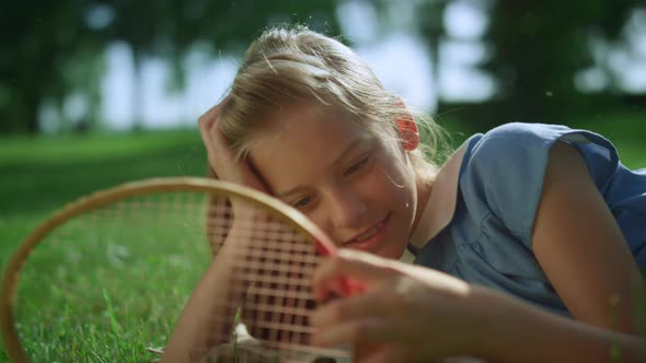 Smiling Girl Lying on Green Lawn Alone