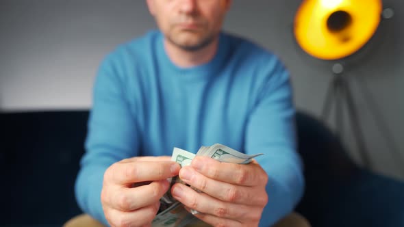 Man Counting US Dollar Bills or Paying in Cash