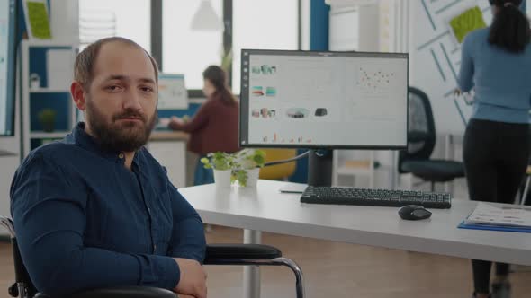 Handicapped Office Manager Looking at Camera