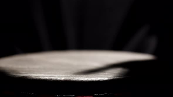 African American Man Plays an African Folk Musical Instrument Bongo Drum in Dark Studio Filled with