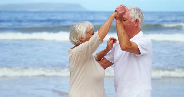 Happy senior couple dancing on the beach