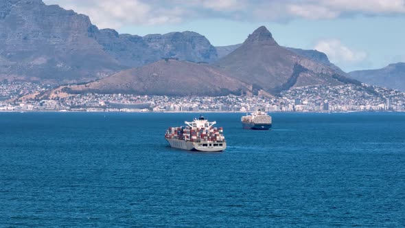 Large cargo ships approach the bay of Cape Town in South Africa. As backdrop the Table mountain and