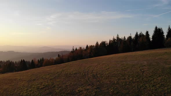 Flight over autumn mountains in the light of the setting sun