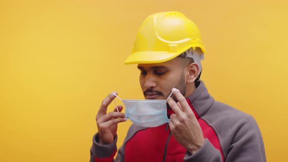 Indian Engineer with Yellow Hard Hat Putting on Medical Mask