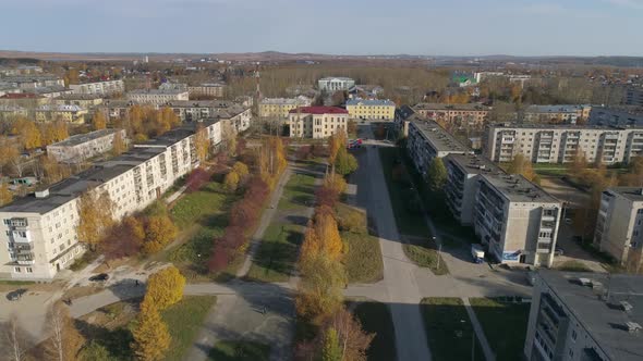 Aerial view of provincial autumn city with soviet panel houses, alley and house of culture 28